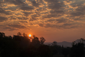 The sun rises over the mountains in the morning.