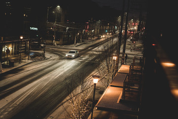 car driving through the street at night in snow storm
