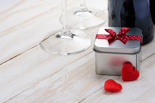 alentine's Day gift box and wine glass on white wooden