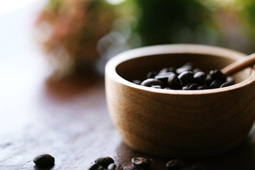 Fototapeta na wymiar Wooden coffee cup with coffee beans closeup soft focus blur background