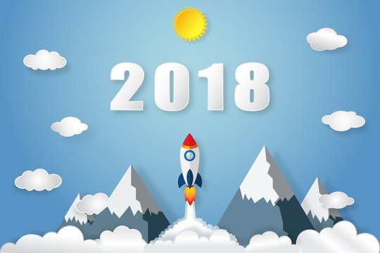 Rocket launch flying to the blue sky, sunny, clouds and 2018 text as paper art, craft style and business new year start up concept. vector illustration. © ImagineDesign