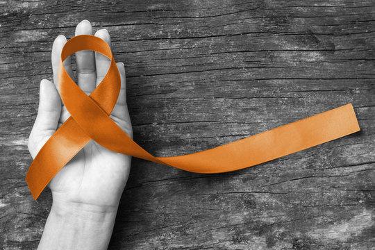 Copper Awareness Ribbon symbolic color for Herpes Simplex Virus  (HSV 1 and HSV 2)  on helping hand support (bow isolated with clipping path)