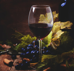 Red wine from grapes of cabernet sauvignon variety, still life in rustic style with berries and...