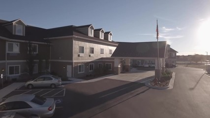 Aerial rotating shot of retirement home by the mountains in small city