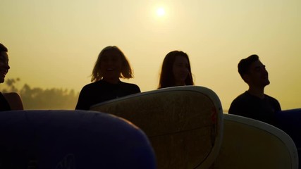 Funny laughing surfers walk with surfboard at sunset beach rapid slow motion 