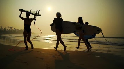 Silhouette surfers run with surfboard beach golden sunrise rapid slow motion - Powered by Adobe