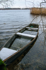 Obraz premium Sunken fishing boat on winter lake in Shatura in Moscow Region, Russia