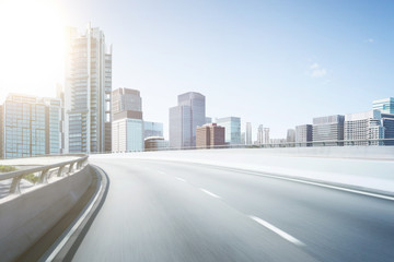 Motion blur flyover asphalt road with modern skyscraper building background.