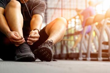 Cropped shot of a man tying his shoelaces before a workout