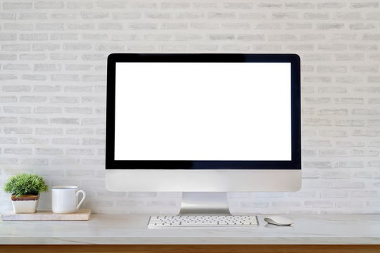 Mockup desktop blank screen computer and coffee mug on table.
