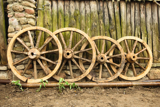 Vintage wooden wheels near old fence