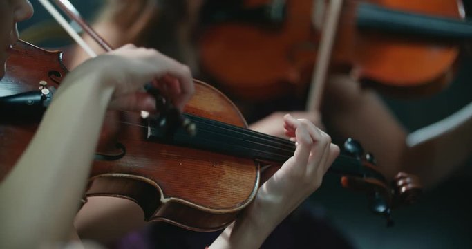 string quartet performs on stage, close-up of violin in work