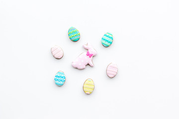 Easter background. Cookies in shape of easter bunny and easter eggs. White background top view space for text