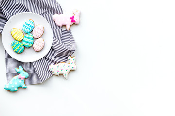 Easter background. Cookies in shape of easter bunny and easter eggs. White background top view space for text