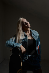 Beautiful blond girl posing with a loangboard