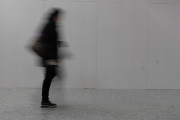 blurry person walking - obrazy, fototapety, plakaty