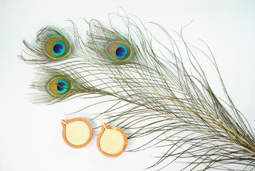 Obraz premium Top or flat lay view of a peacock feathers on a white background with a words HAPPY THAIPUSAM DAY. Celebrate by a hindu religions. A religions conceptual.