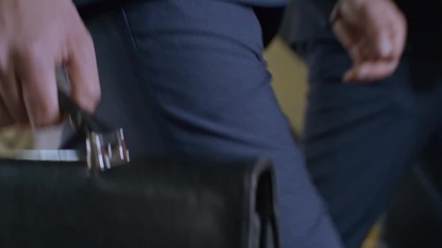 Close up of unrecognizable businessman carrying briefcase and walking to work