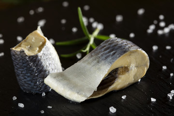Marinated herring fish with salt on slate