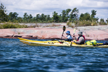 A group of active seniors on a guided sea kayak trip on the Great Lakes in Ontario, Canada.
