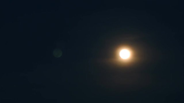 time-lapse of rising moon through the cloud and vapor and sky become darker
