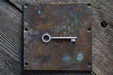 Metal key on an old copper plate