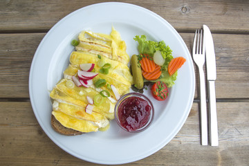 Delicous Baked Camembert on Bread Served with Cranberry Jam and Salad in Germany