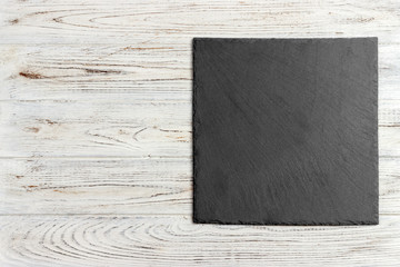 black slate stone on wooden background. copy space
