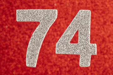 Number seventy-four silver color over a red background. Anniversary