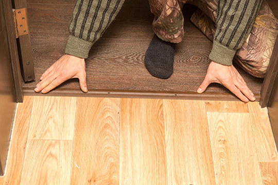 A man is making a threshold on the floor