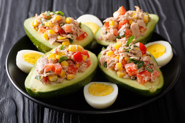Delicious food: healthy salad of avocado, tuna, eggs and vegetables close-up on a plate on a table. horizontal