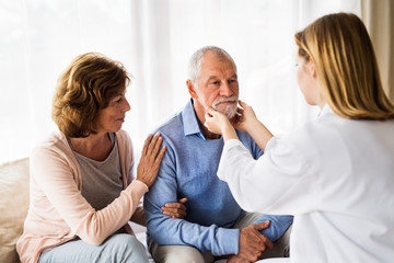 Female doctor examining a senior man.