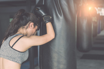 Asian young woman doing exercise with Thai boxing (Muay Thai) equipment in gym. Health and fitness...