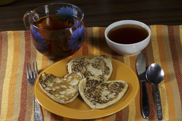 Breakfast at Valentine's Day. Pancakes, jam, cottage cheese and tea.