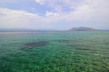 Blue-green sea water with small waves and light reflection