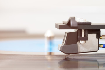 Needle on vinyl record. Close up of turntable stylus and lp plate, blurred background, copy space