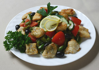 Fresh vegetable salad with fillet of fish on plate.