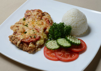 Chopped beef with fresh greens and rice on a plate.