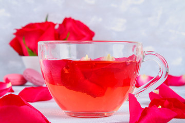 tea made from tea rose petals in a glass bowl on grey table.