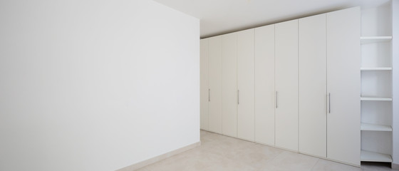 Interior of modern empty apartment, white wardrobe
