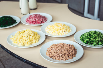 Chopped Meat with vegetables on the plate. A set of products for okroshka. Traditional Russian dish okroshka.