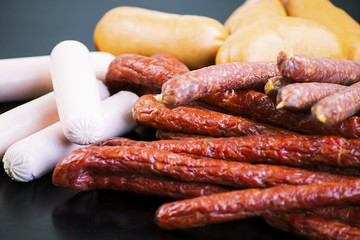 different meat sausages on a black background