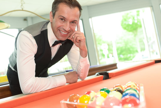 man posing on the billiard table
