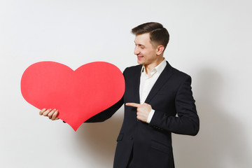 Young man in suit pointing index finger on big red heart isolated on white background. Copy space, advertisement. Place for text. St. Valentine's Day, International Women Day birthday holiday concept.