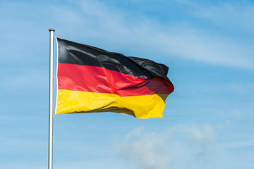 German flag waggling in the wind with sky in background