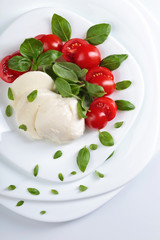 Mozzarella with tomato and green basil.