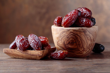 Juicy dates on wooden table .