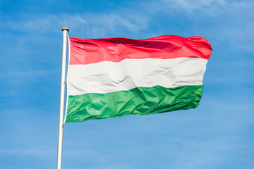 Hungarian flag waggling in the wind with sky in background