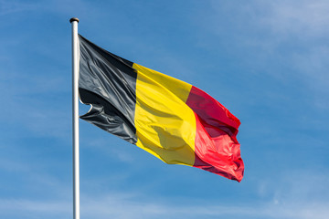 Belgian flag waggling in the wind with blue sky