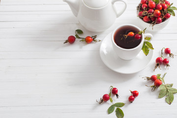 tea with berries of a dogrose on a wooden background